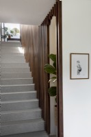 Walnut wood panelling bordering staircase leading up to front entrance