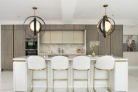 Classic contemporary kitchen with large pendants over marble island.