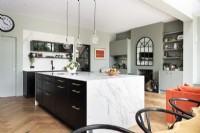 Contemporary large kitchen island with black units and marble top.