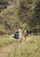 Two women walking through the countryside in vintage clothing 