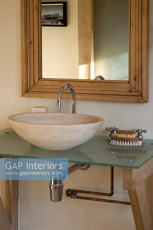 Boonshill Farm, East Sussex. Interior of bathroom with stone basin on glass top. 