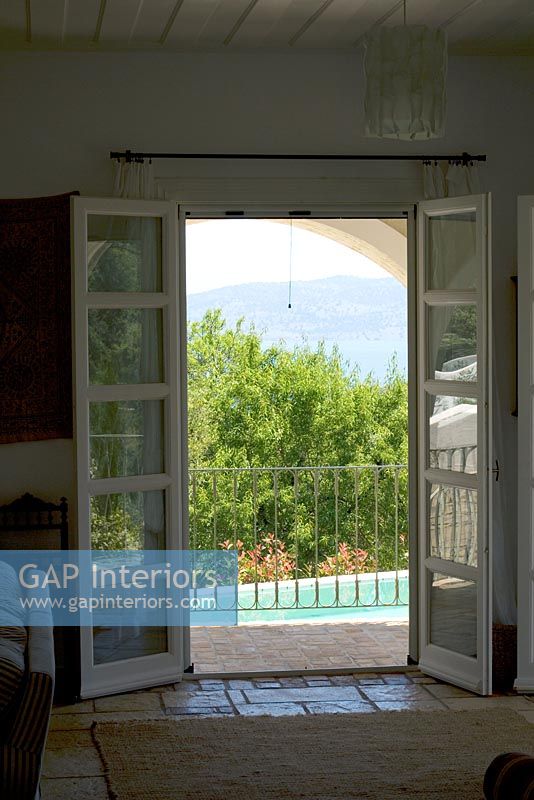 Corfu, Greece. Yialiskari House Villa near Kalami. View through living room to pool and Albanian Mountains