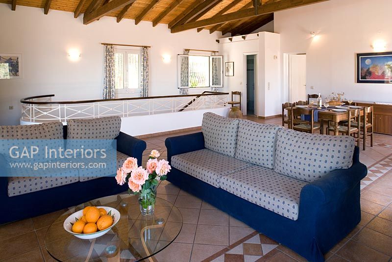 Villa Christina, Kaminaki, Corfu, Greece.  Open plan living and dining room with sofas and dining table
