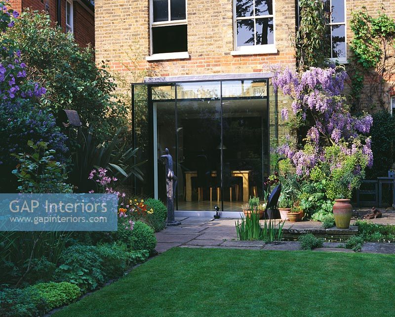 View of modern glass extension and back garden