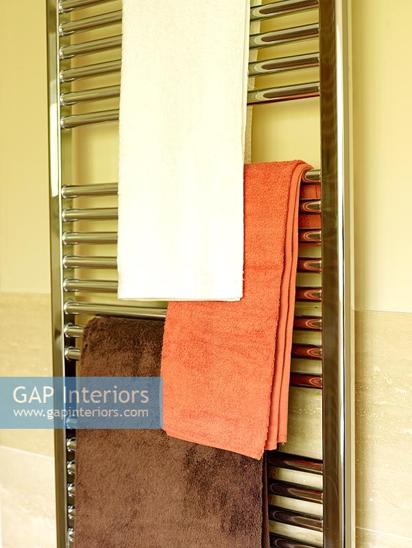 Detail of heated towel radiator in bathroom 