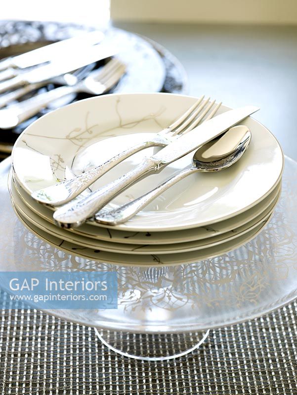 Detail of plates and cutlery on dining table 