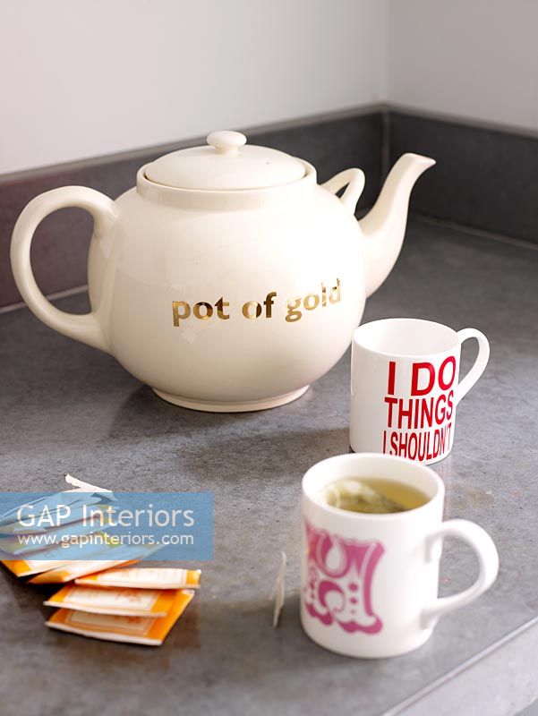 Teapot and mugs on kitchen worktop