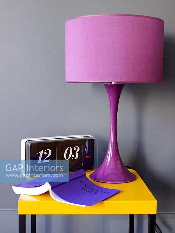 Detail of purple retro lamp on side table with retro clock