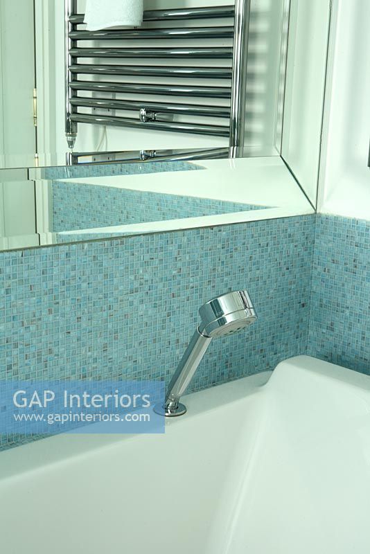 Modern bath with blue mosaic tiles and handheld shower