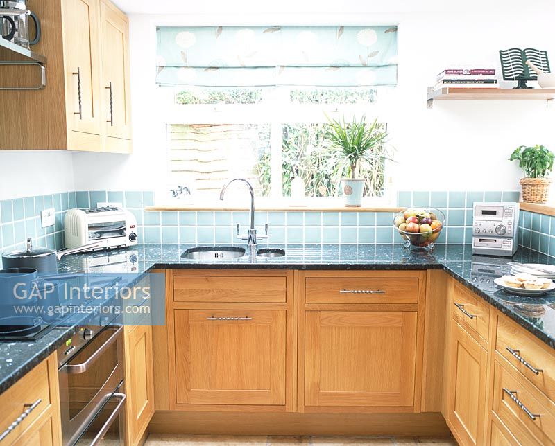 Kitchen with traditional wooden units and green tiled splashbacks 