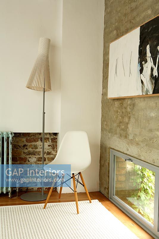 Living room with chair, Seppo Koho lamp  and exposed brick wall