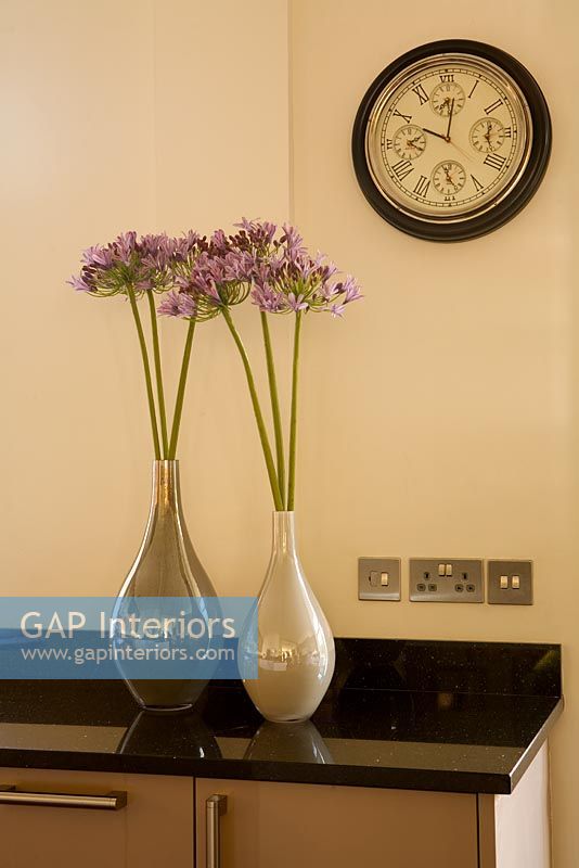 Kitchen worktop with flowers in vases 