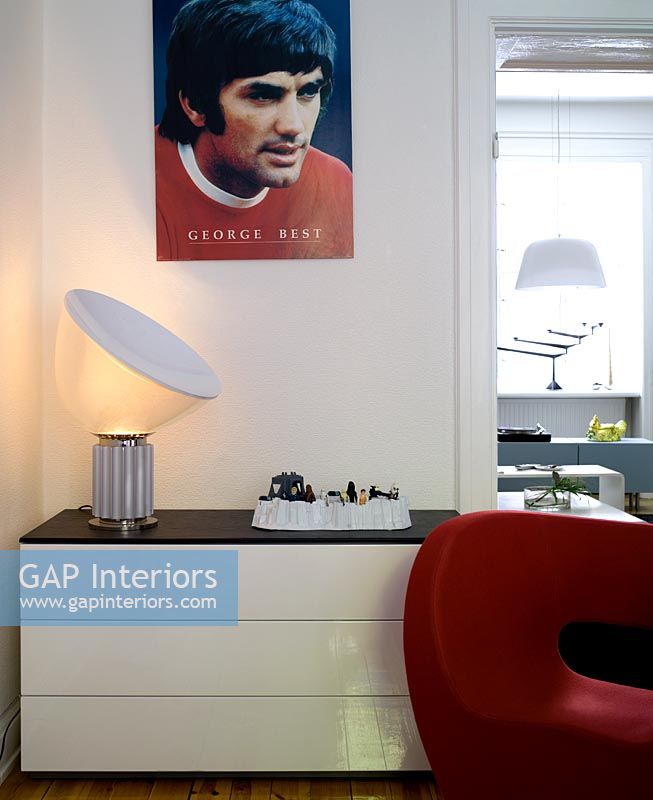 White set of drawers with Ron Arad red chair and George Best poster