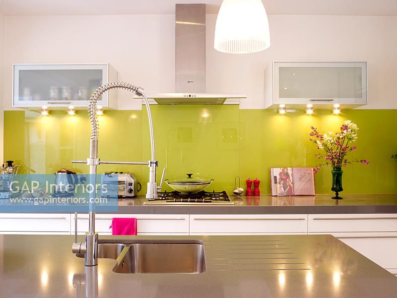Modern kitchen with green glass splashback