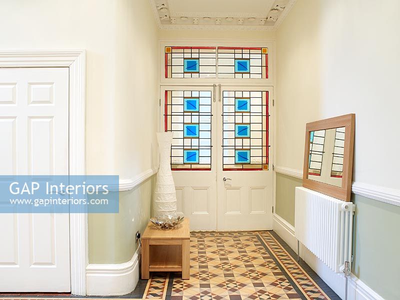 Hallway with patterned tiled floor and stained glass doors