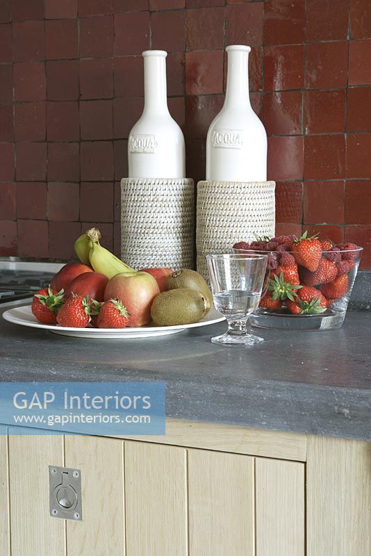 Fruits in plate and bowl on kitchen worktop