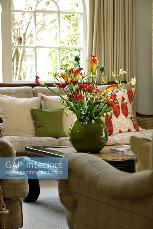 Living room with beautiful display of flowers - Calla lilies, Ranunculus, Tulips and Kangaroo paw in green container