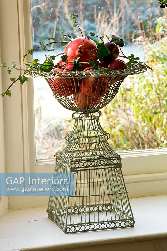 Ornate wire containers with apples, ivy and pomegranites