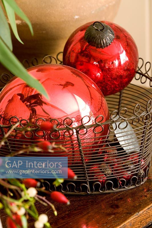 Decorative red christmas tree baubles in a wire rack