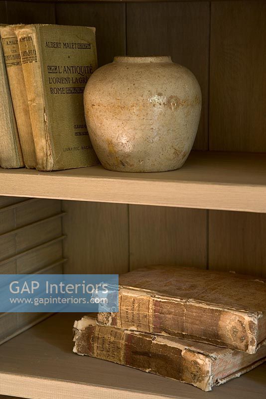 Stack of books and vase on shelf