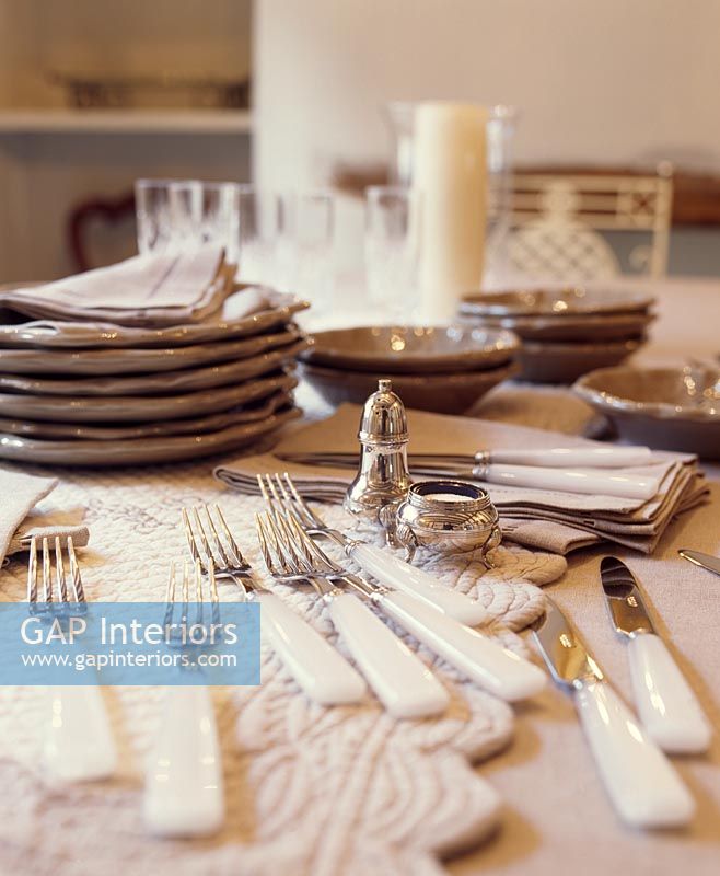 Cutlery, plates and placemats on dining table