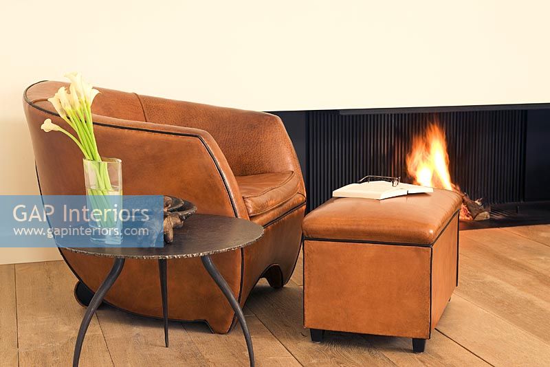 Armchair and ottoman next to a fireplace