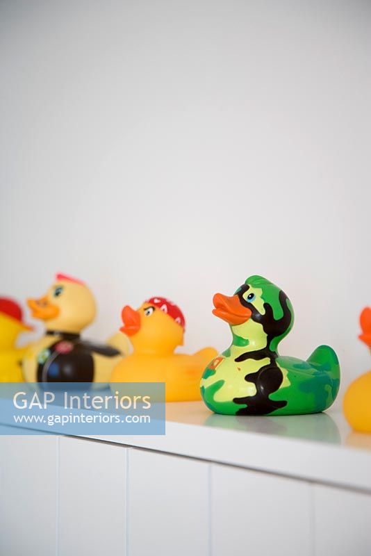 Colourful rubber ducks on shelf, detail