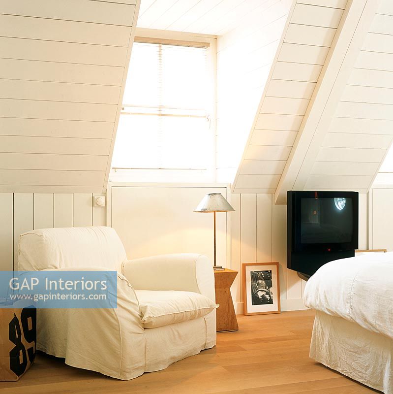 Attic bedroom with white armchair