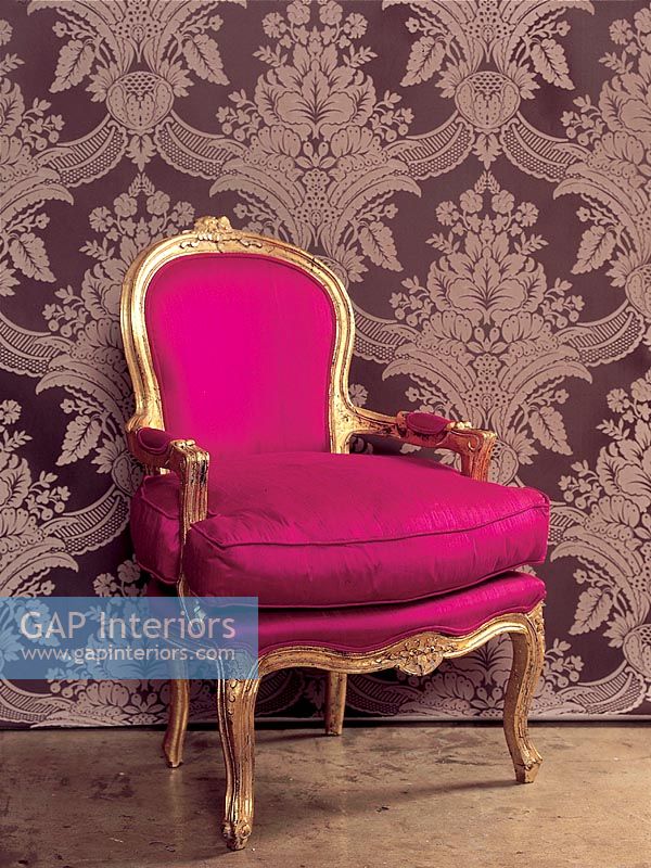 Purple armchair in front of wallpaper