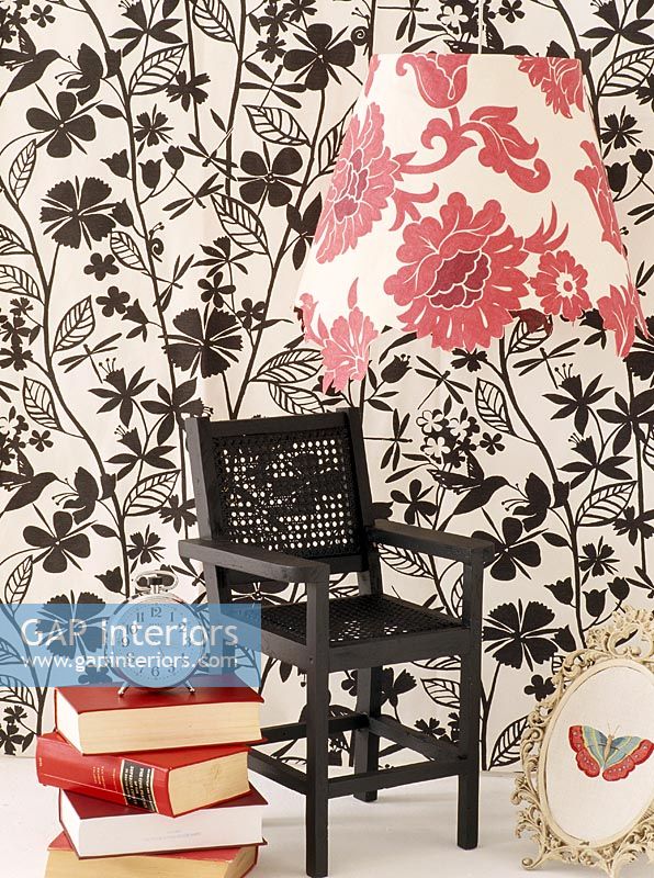 Small black chair in front of wallpapered wall