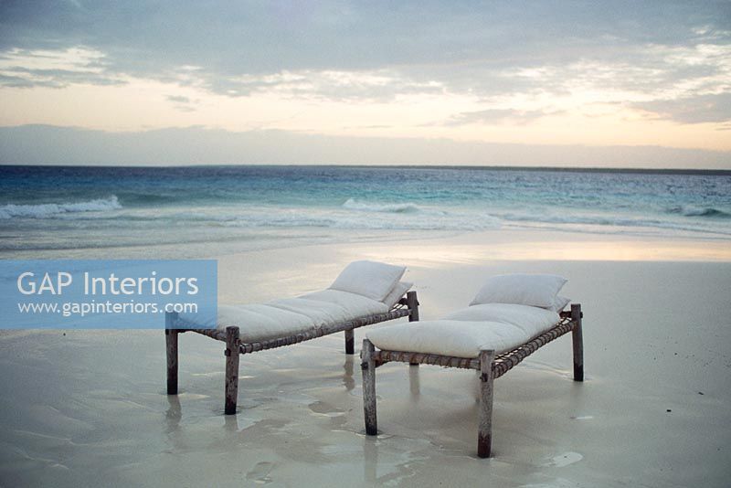 Two daybeds on a beach