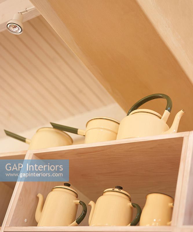Teapots on kitchen shelf, low angle view