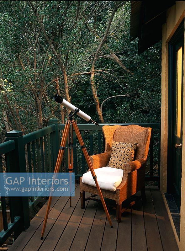Small wooden balcony with an armchair and telescope
