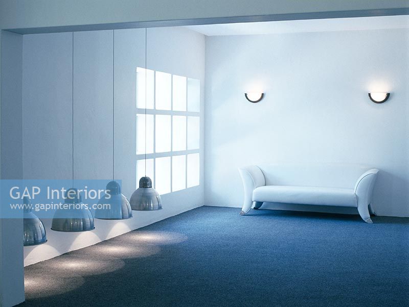 Minimal room with a sofa and low hanging lamps