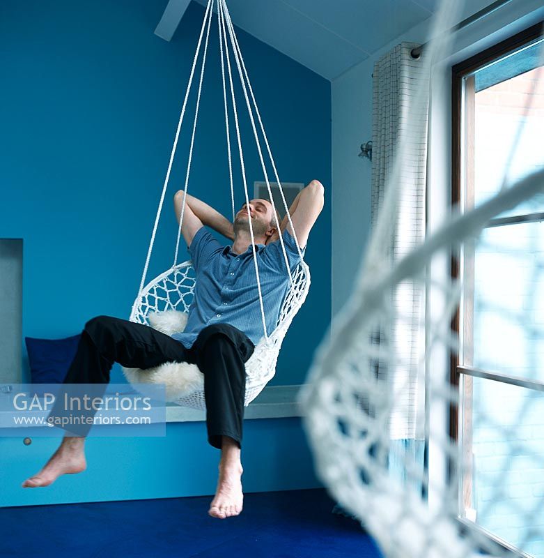 Man sitting in a hanging chair relaxing