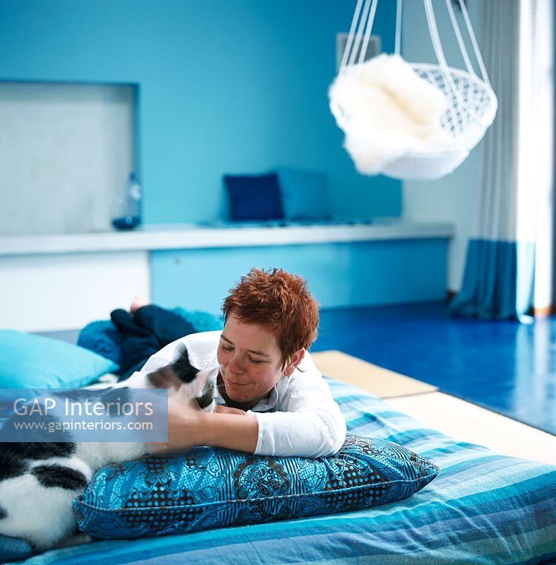 Woman laying on a bed with a cat