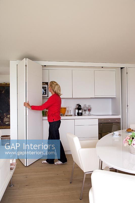 Woman opening concealed kitchen