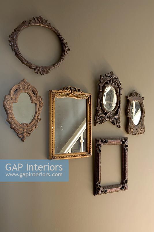 Display of frames and mirrors on wall