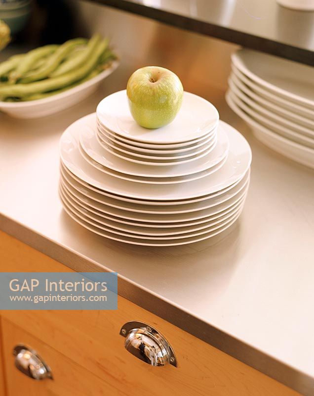 Green apple on stack of plates