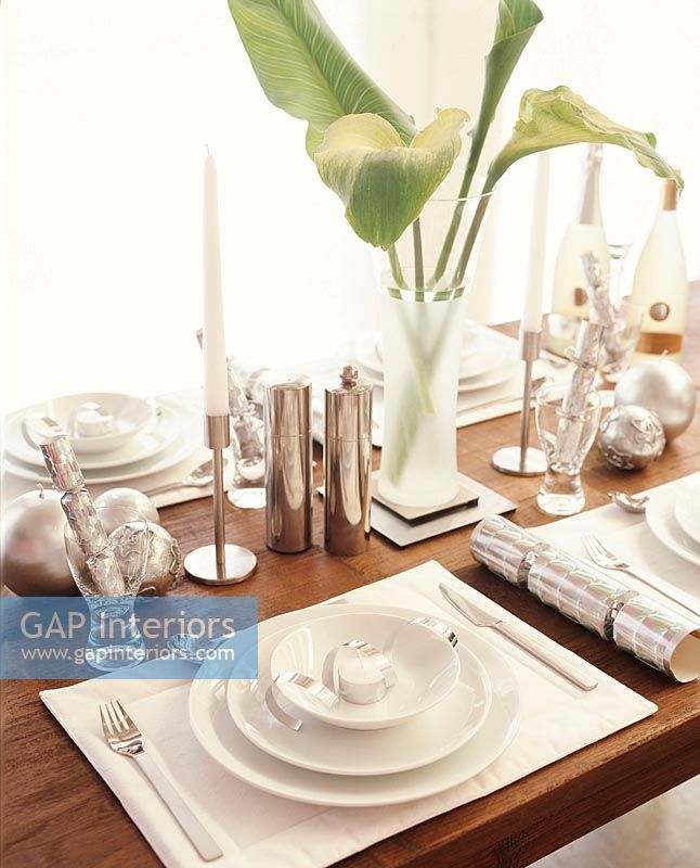 Place setting on dining table with flowers and candle sticks