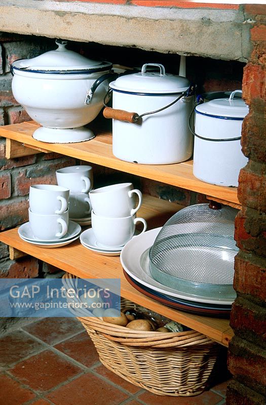 Cookery and tableware on kitchen shelves