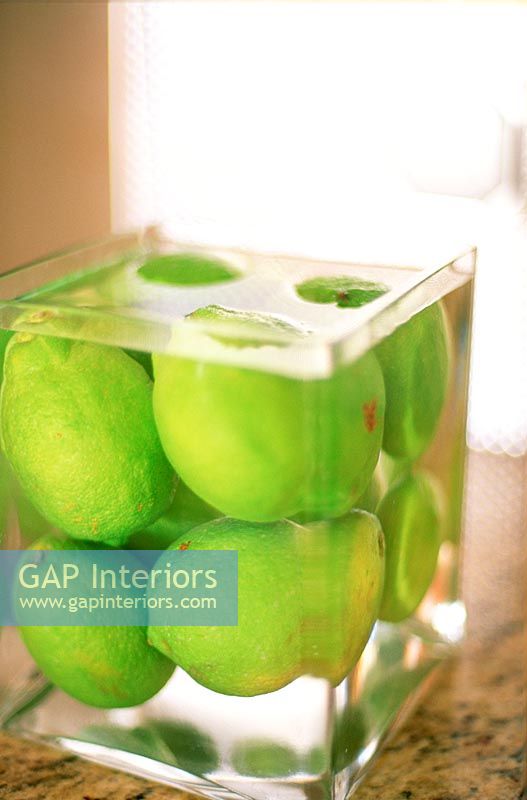 Limes in a square vase full of water