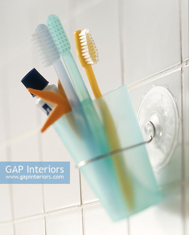 Toothbrush and toothpaste in glass, close-up