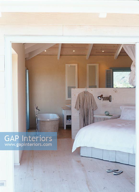 Interior of bedroom with bathtub and bathrobe