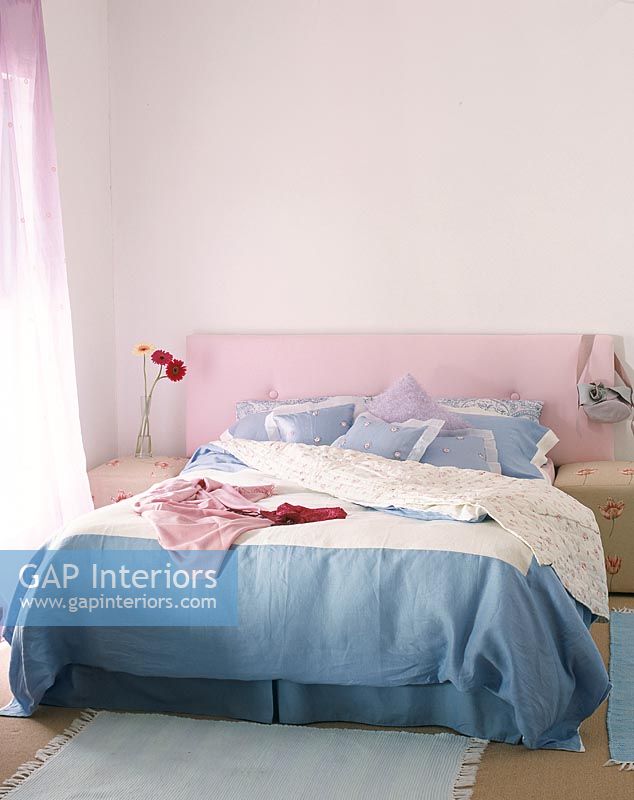 Interior of modern bedroom with clothes on bed