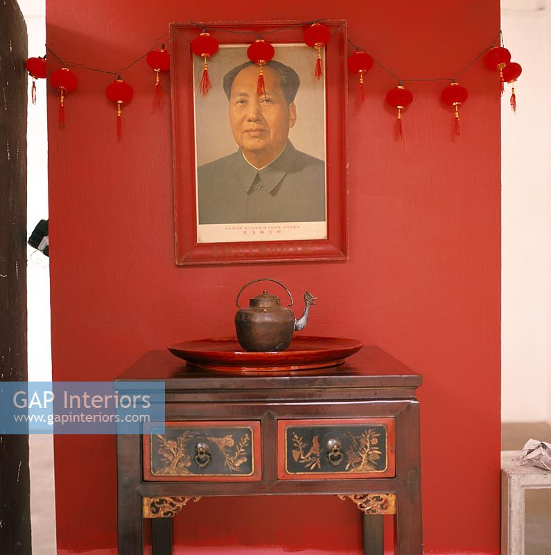 Teapot on plate on side table with photo of Mao Tse Tung