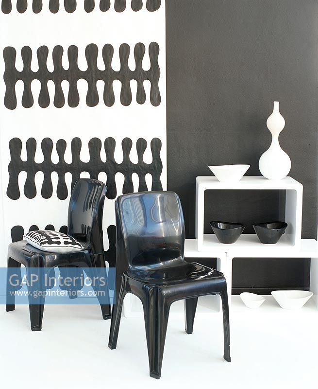 View of chairs and bowls on shelf by wall