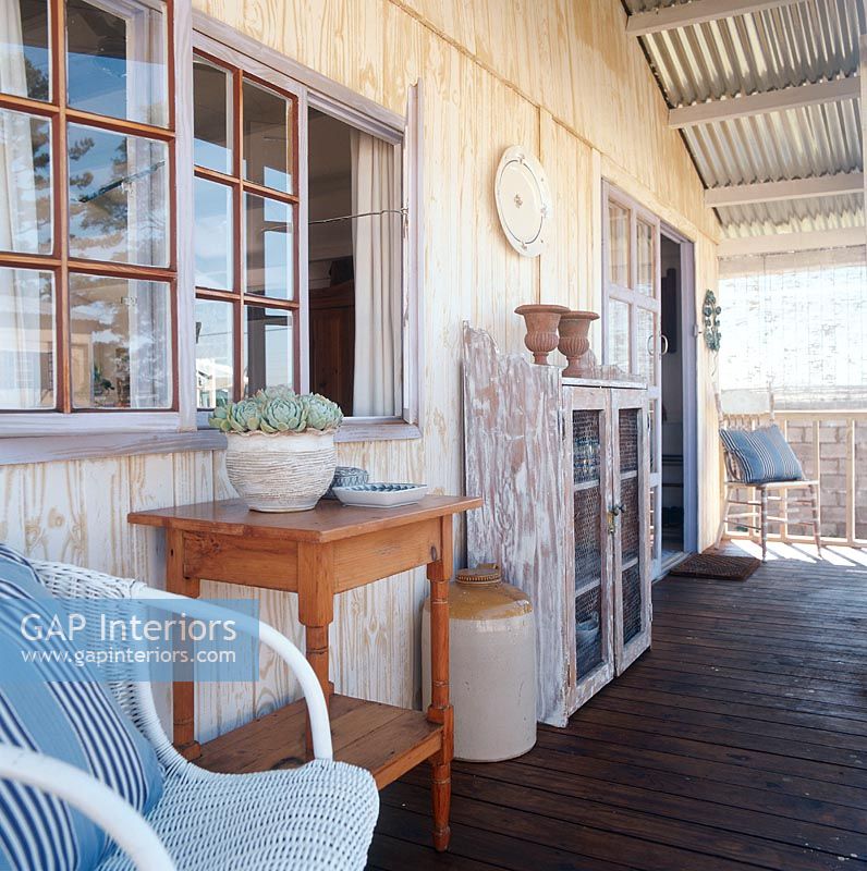 Front porch with wicker chair and corrugated iron roof