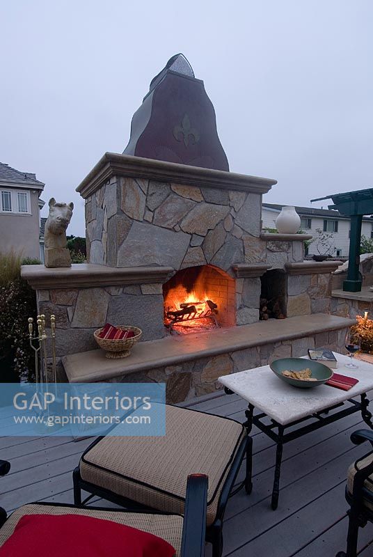 Outdoor kitchen and fireplace with fire