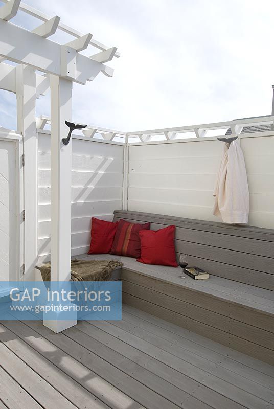 Wooden deck with built in bench and red pillows